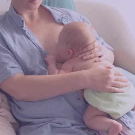 Maria the Doula providing compassionate guidance and face to face breastfeeding support to a new mother and baby.